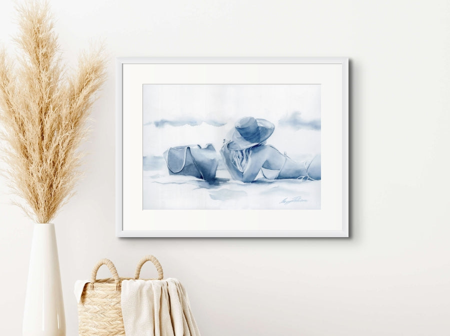 A coastal wall art watercolour painting of a sunbather on the beach wearing bikinis and a large hat