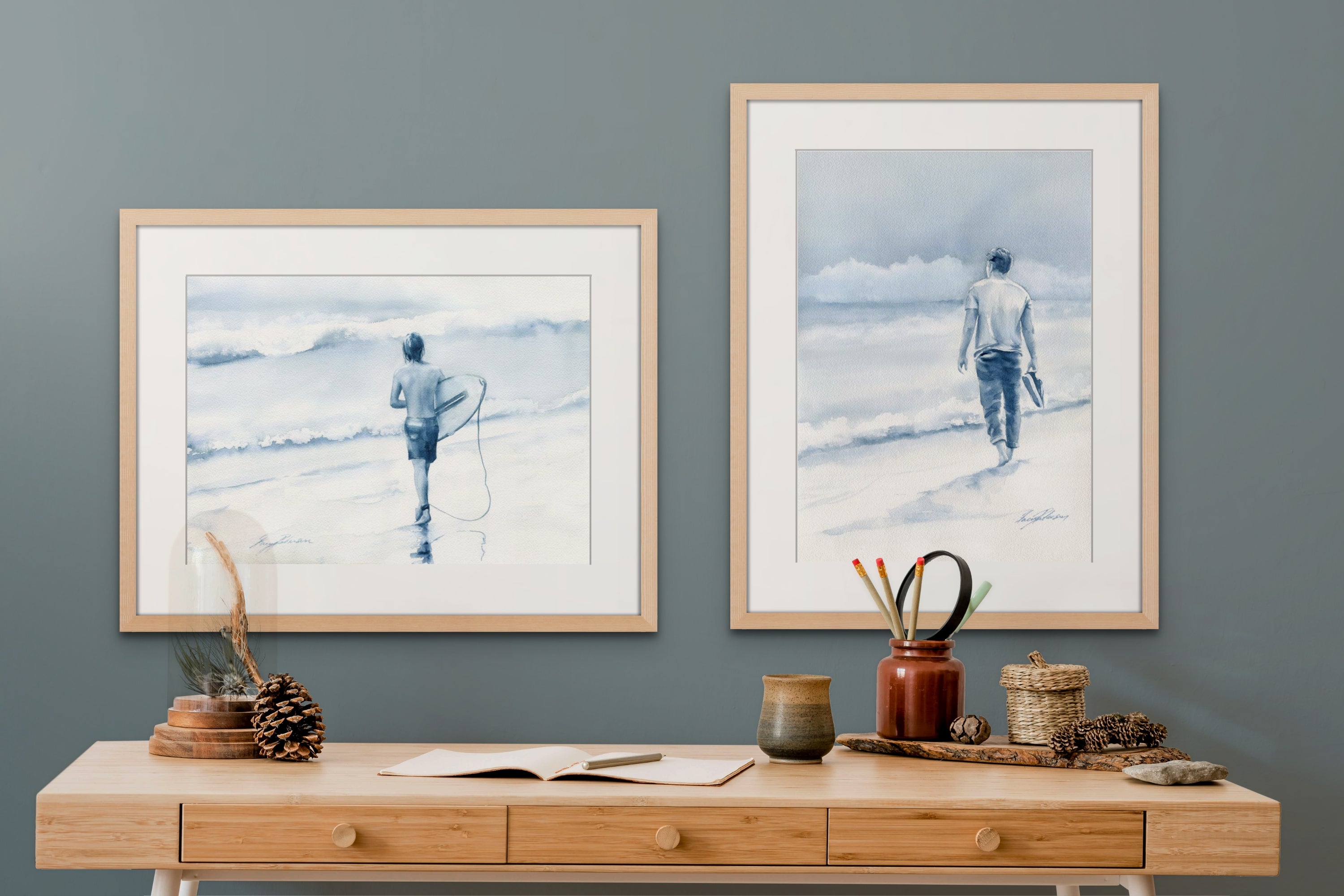 Two coastal art watercolour paintings of beach lovers. One surfer walking with his board into the surf. One man walking on a beach with storm clouds on the horizon.